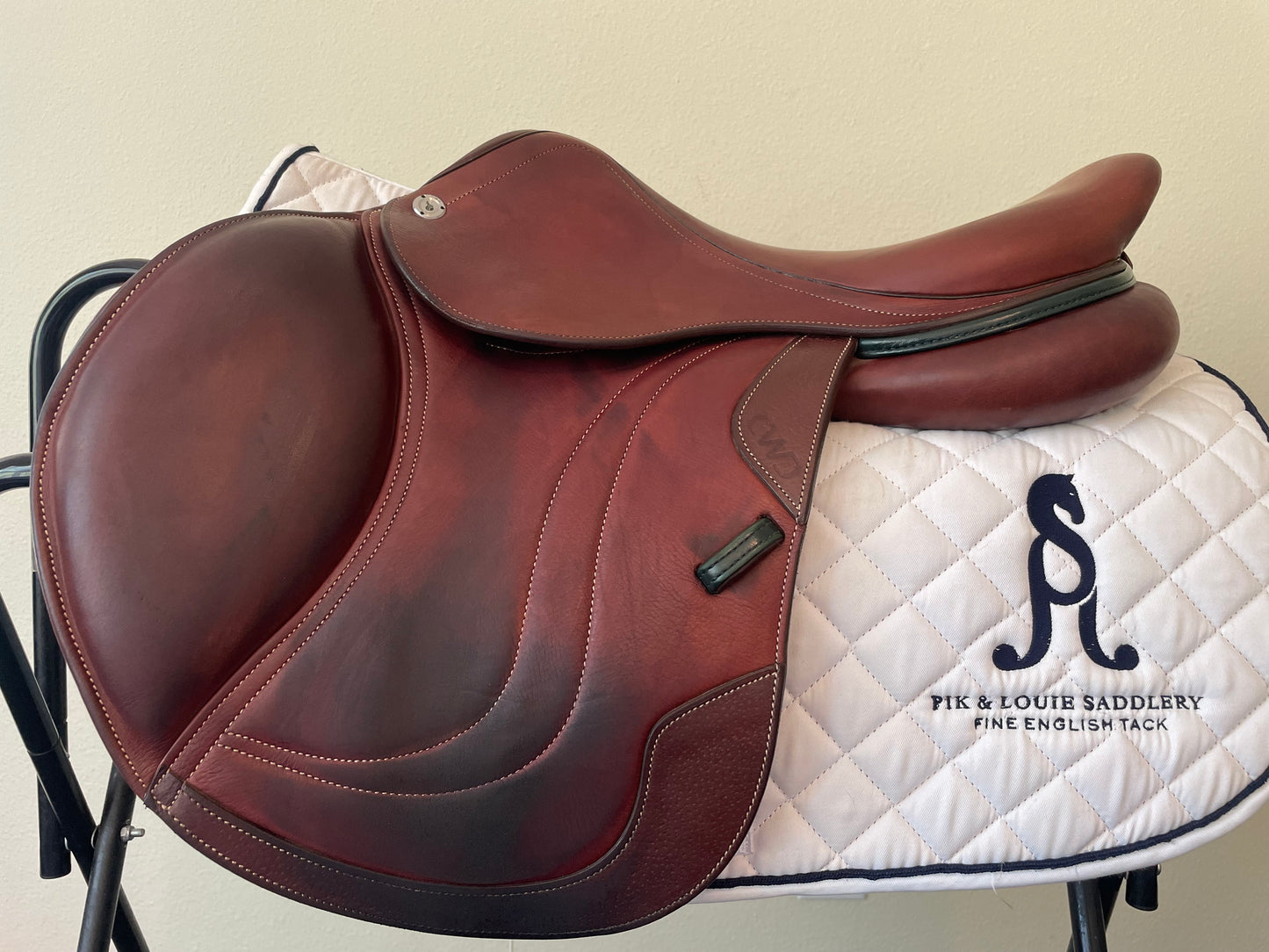 A brown CWD SE03 saddle with a 1C flap, Panel 710 RT, displayed on a white saddle stand, showing the semi-flat seat and narrow twist.